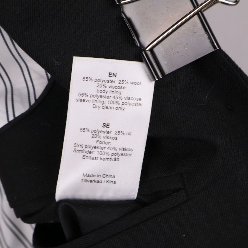 Materialetikett med information om polyester, ull och viskos