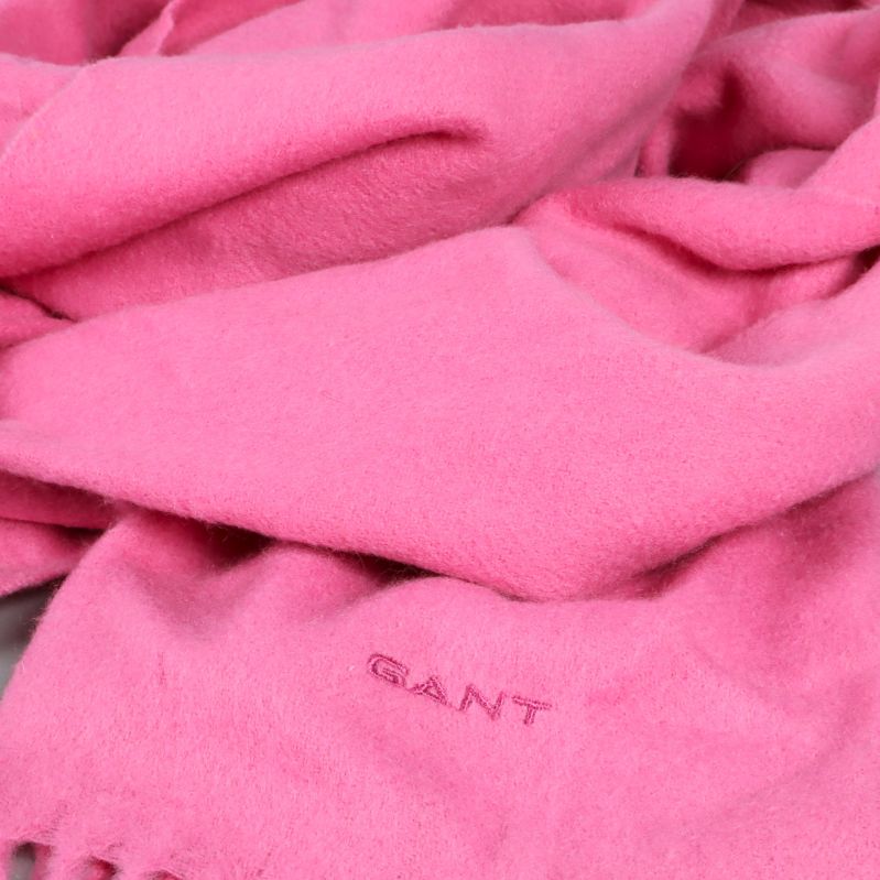 Närbild på rosa halsduk i ett mjukt tyg med GANT-logga