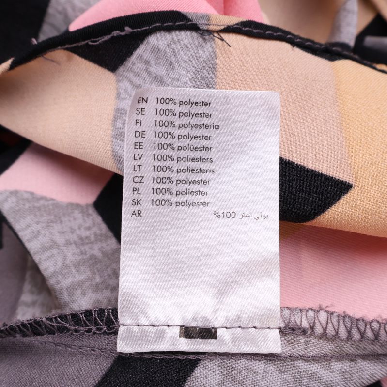 Materiallapp visar 100% polyester på insidan av klänningen