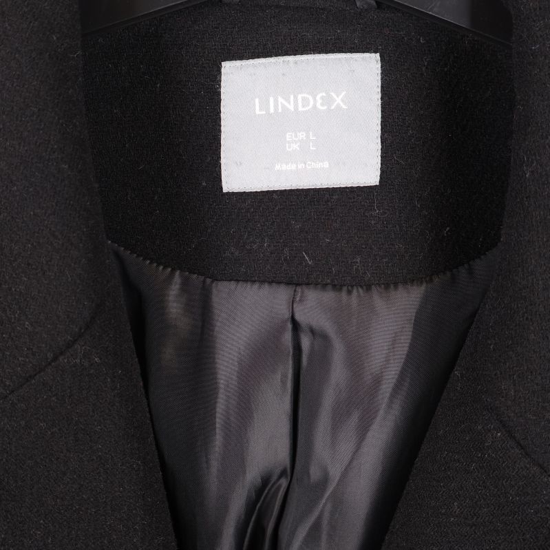 Närbild på Lindex-logotypen i kappans nacke