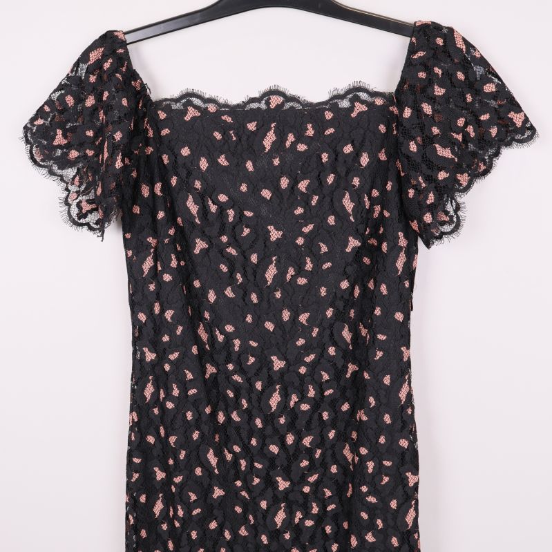 Närbild på klänningens överdel och volangärmar i spets