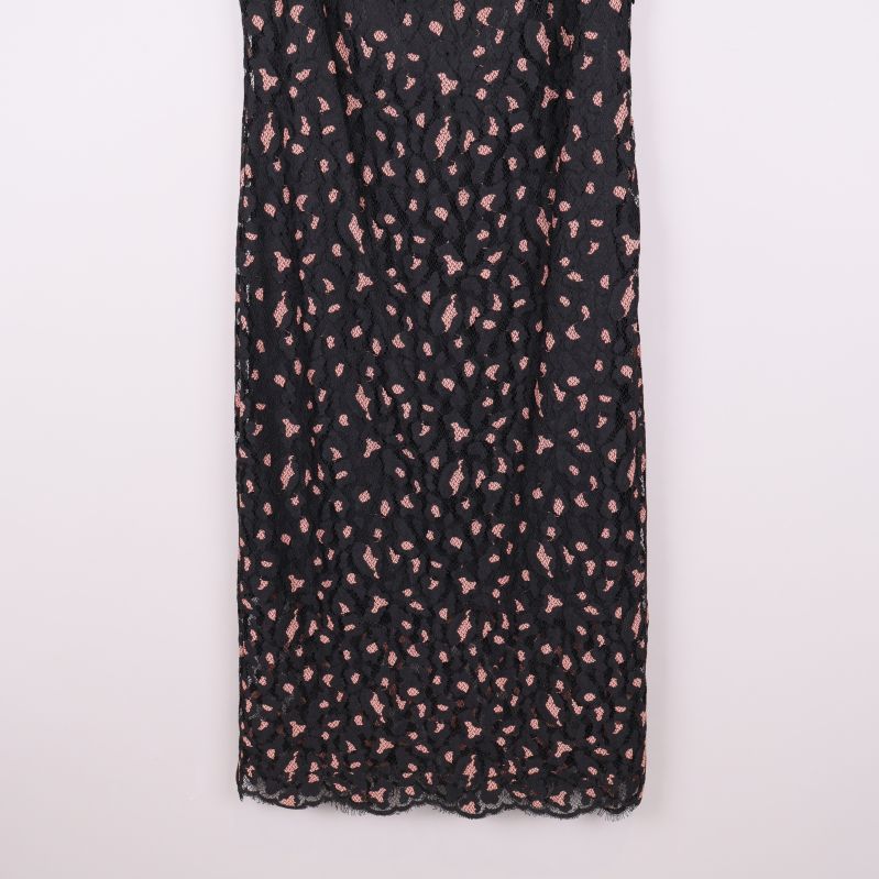 Underdel på svart spetsklänning med rosa detaljer och vågig kant