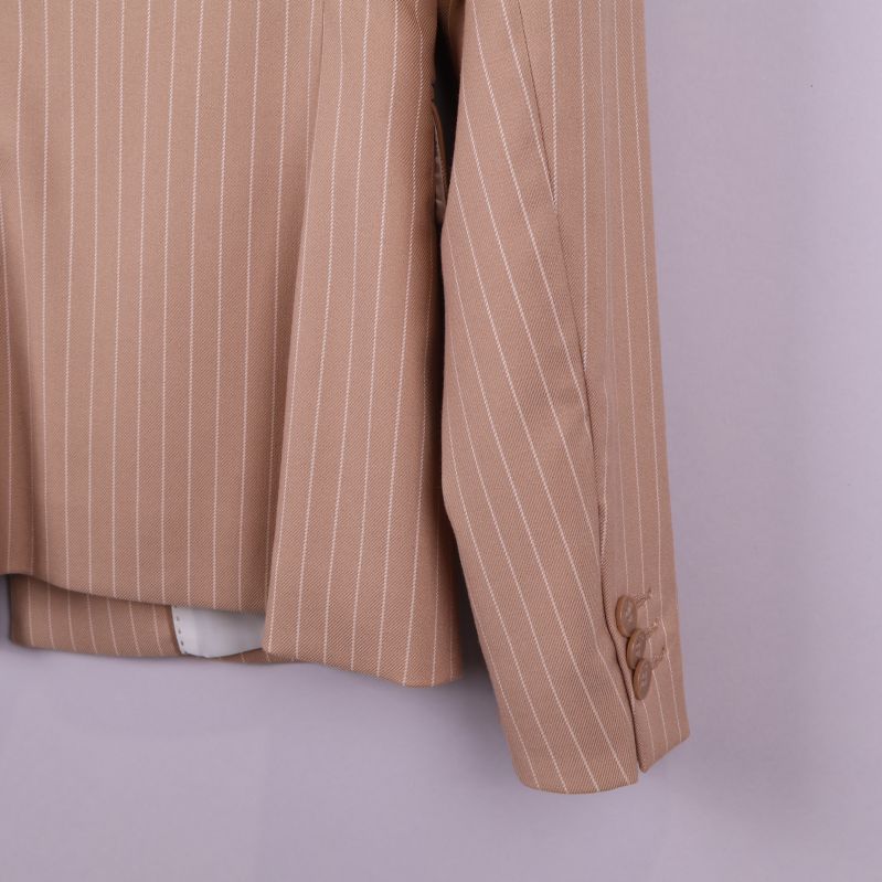 Närbild på ärmslut och tygdetaljer på beige randig kavaj