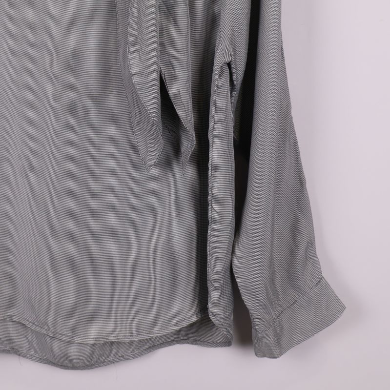 Blusens ärmslut och del av nederkant i närbild