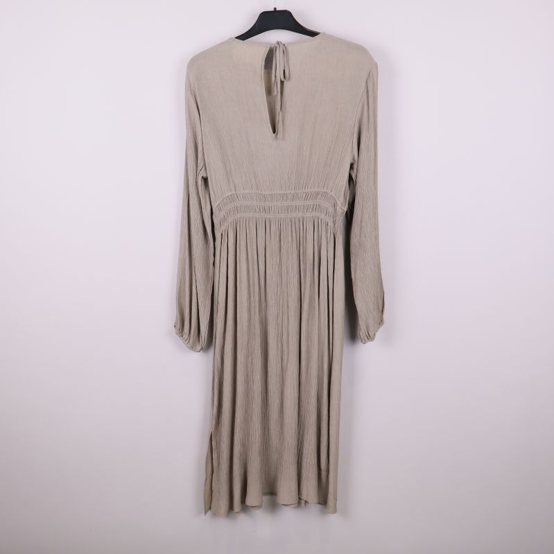 Helbild bakifrån av beige klänning med knytning i nacken