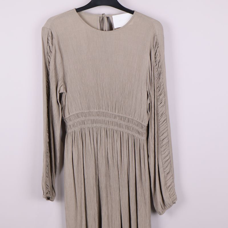 Närbild på klänningens struktur och plissering