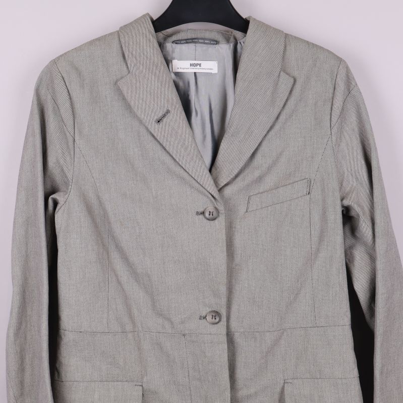 Kavajens överdel framifrån med fickor och knappar