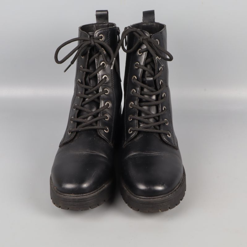 Framifrån syn på svarta snörade boots