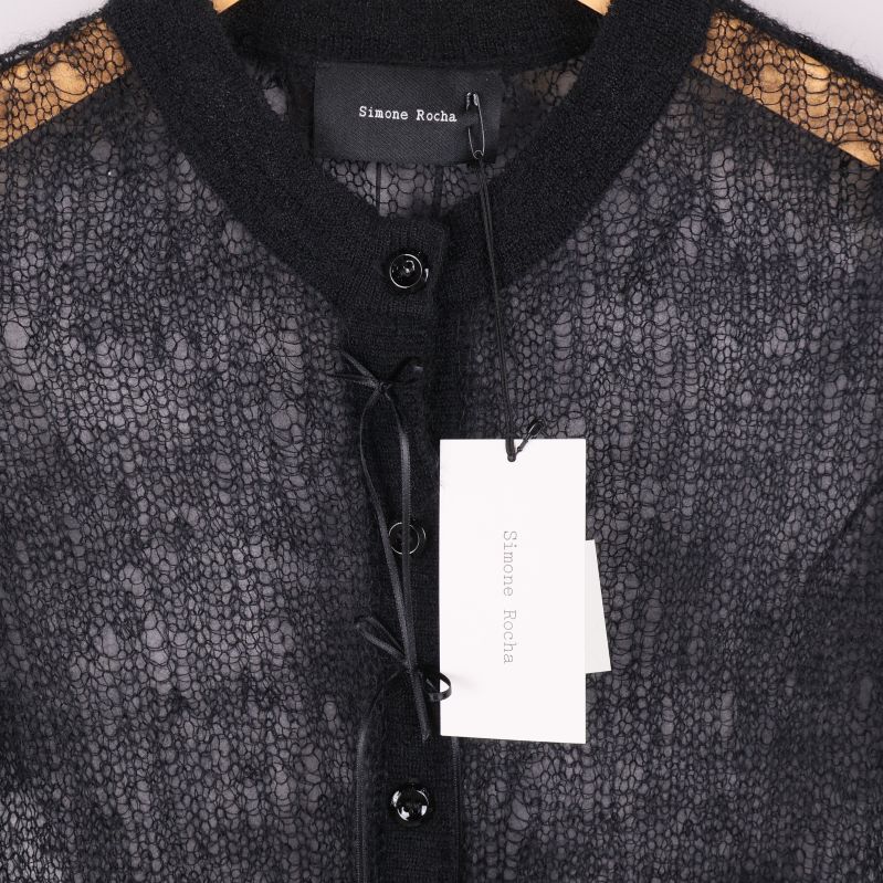 Närbild etikett och snörning på svart kofta