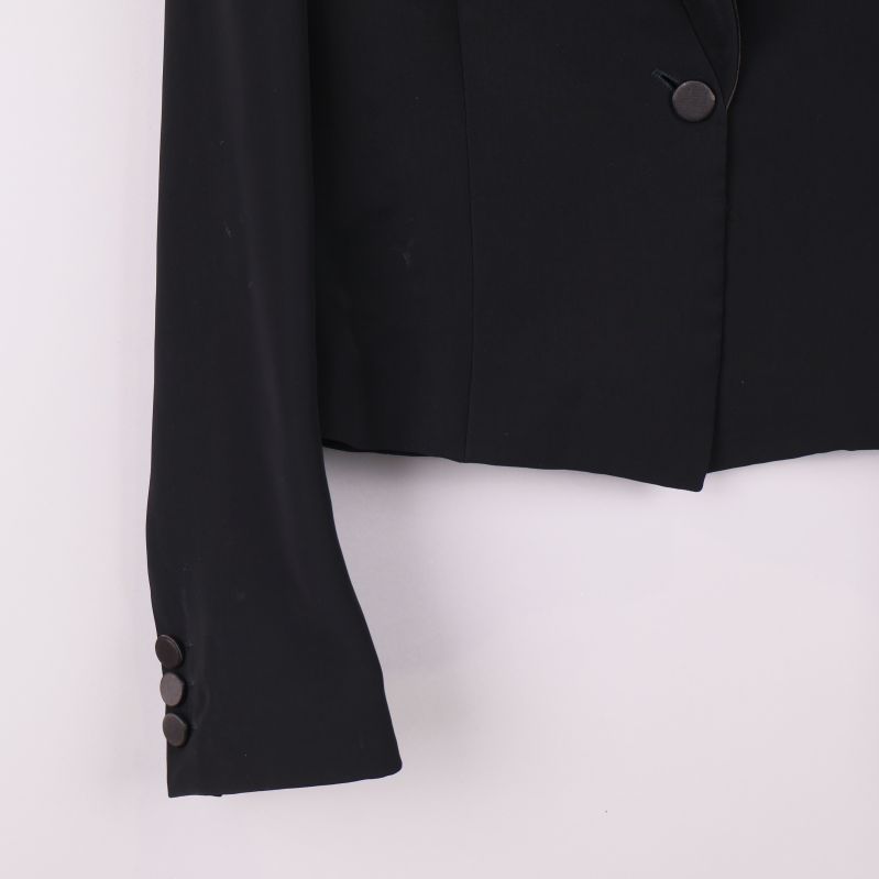 Närbild på ärmslut med dekorativa knappar i svart kavaj