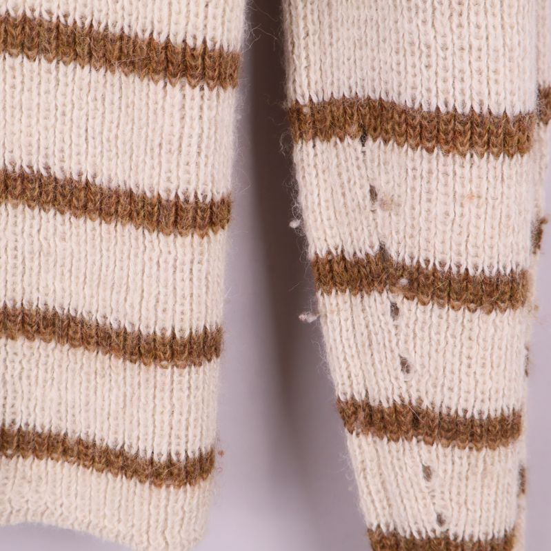 Närbild på tröjans ärm med bruna ränder