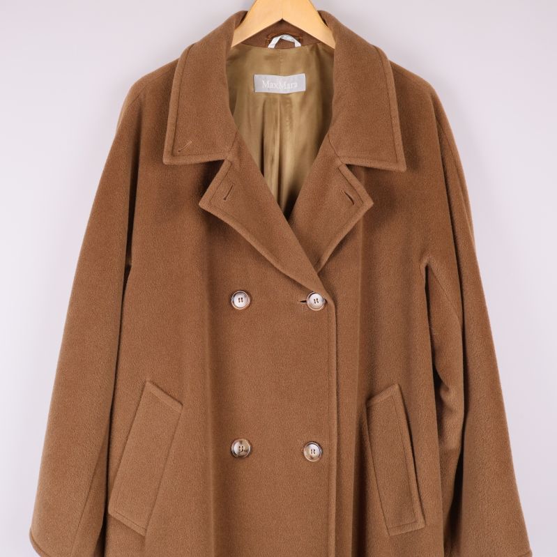 Närbild av övre del av brun kappa med bred krage och knappar