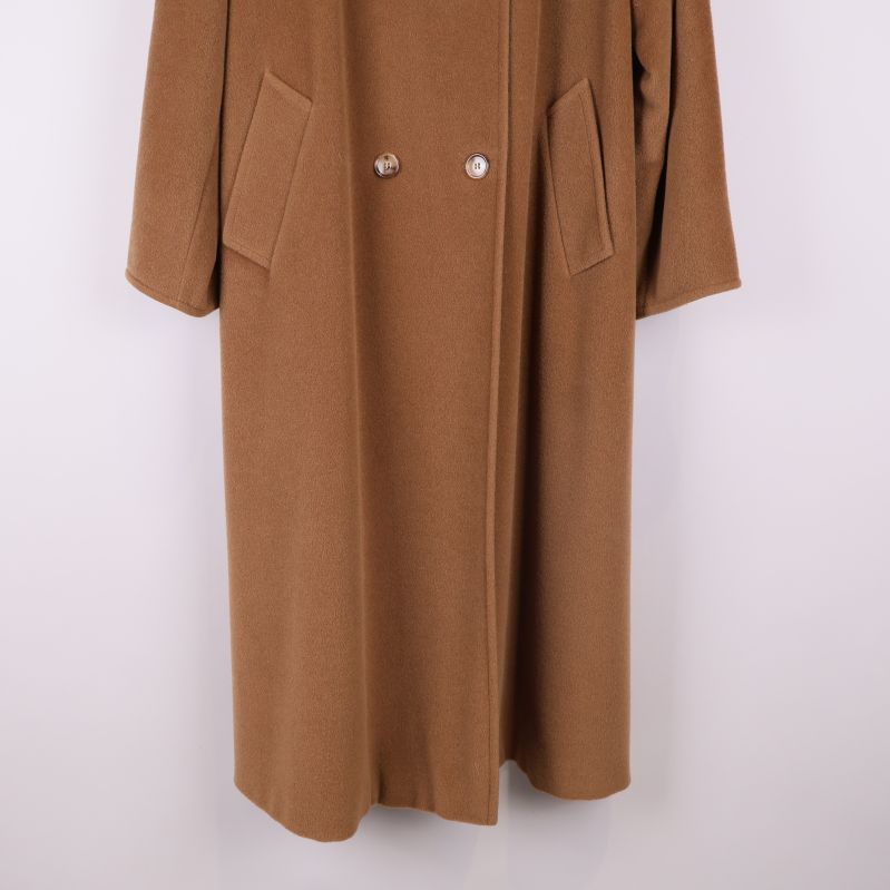 Nederdelen av brun långkappa med fickor visas i fokus