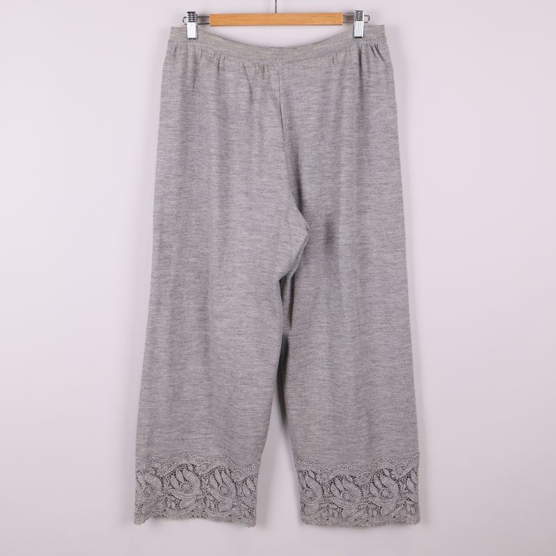 Baksida av grå stickad byxa med spetsdetalj