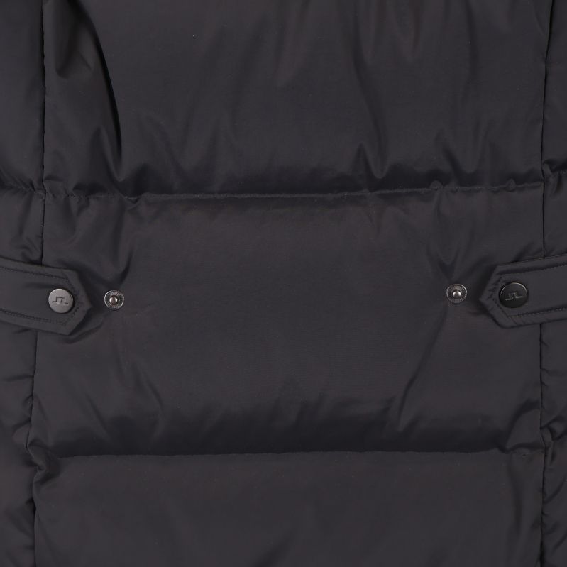 Närbild på justerband med knapp baktill på jackan