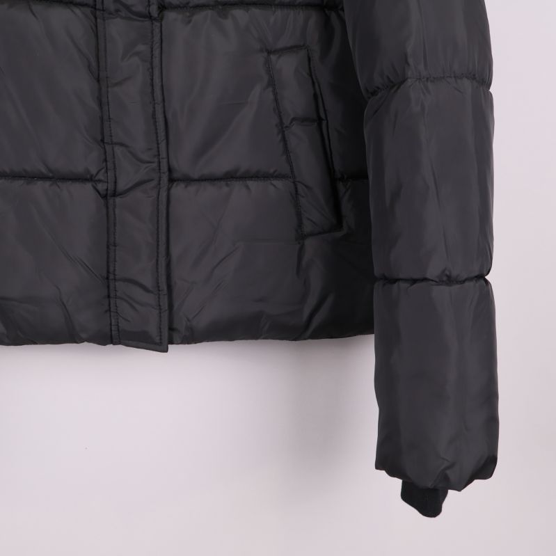 Närbild på andra fickan och ärmslut på svart jacka