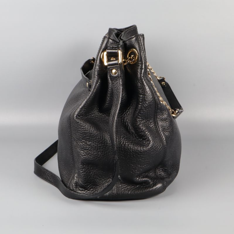 Sidan på väska med gulddetaljer och axelrem