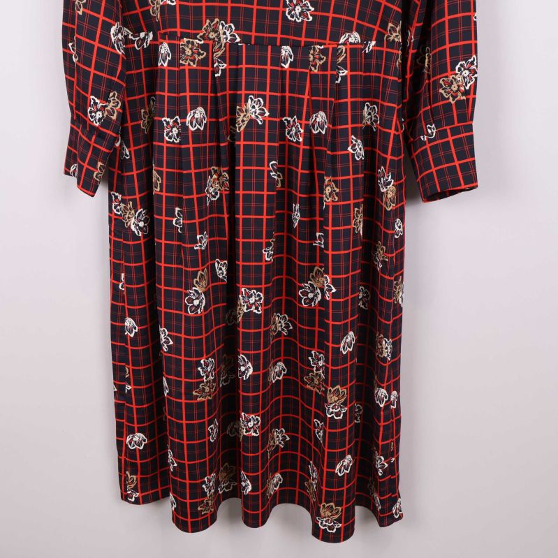 Nedredelen av klänning med rutigt blomtryck visas