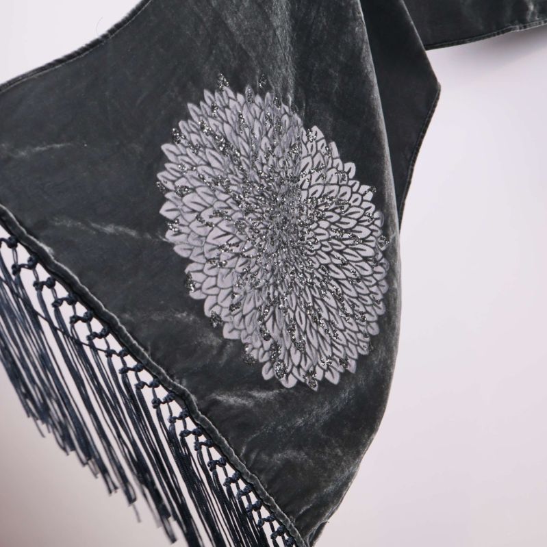 Närbild på blomformad brodyr längst ut på scarfen