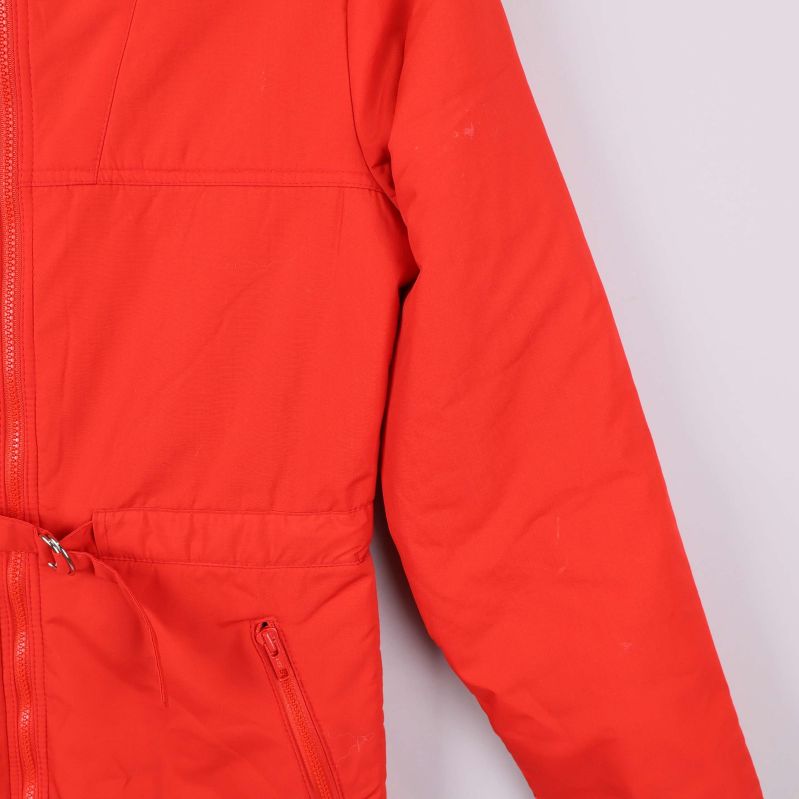 Närbild på vänster ärm och ficka med dragkedja