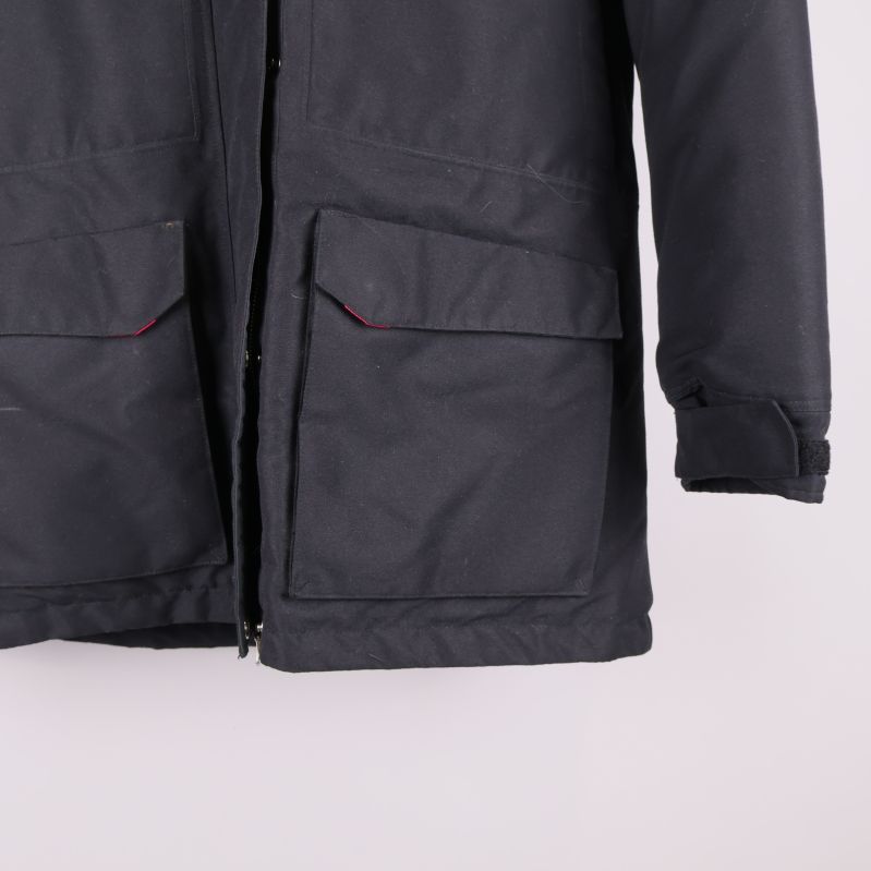 Nedre delen av svart jacka med stora fickor