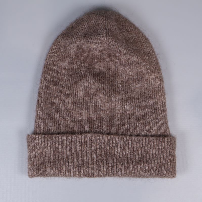 Stickad brun mössa liggande platt uppvikt kant