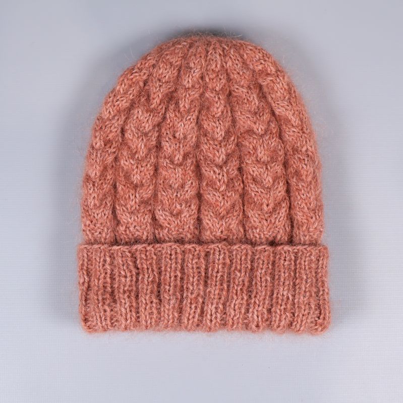 Baksidan av kabelstickad mössa i varm färg