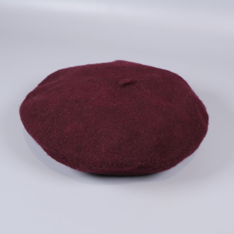 Vinröd basker på vit bakgrund