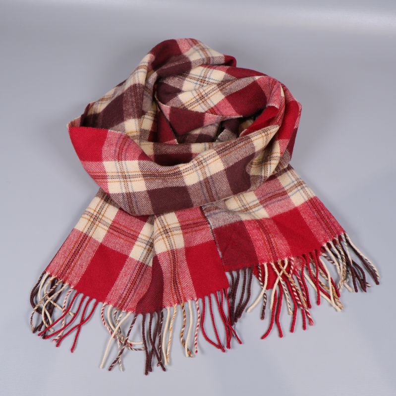 Halsduk i rutig design liggande med fransar synliga