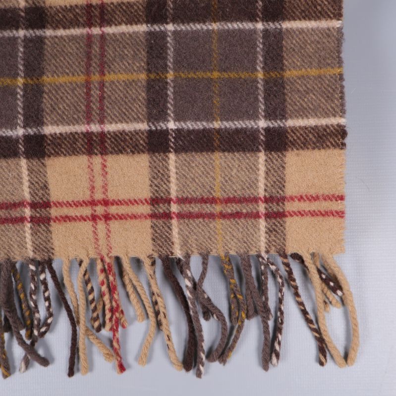 Närbild på fransar och rutigt mönster i nederkant