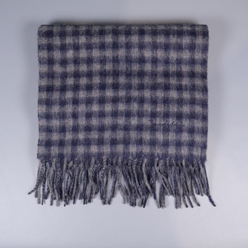 Rutig halsduk med fransar vikt fyrkantigt framför vit bakgrund