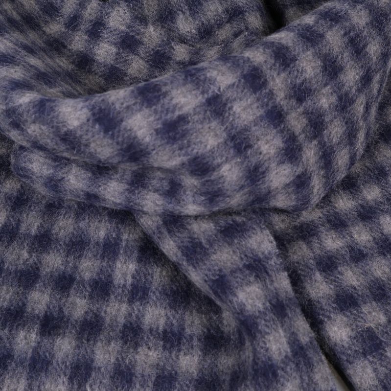 Närbild på halsdukens blå och beige rutor med mjukt material