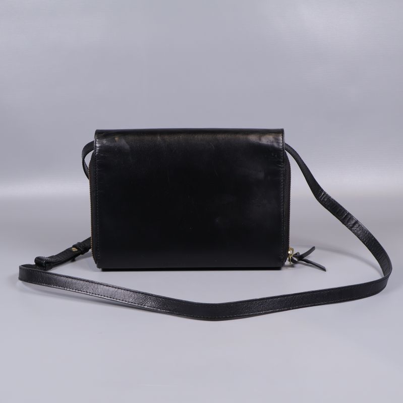 Baksidan av slät svart axelremsväska med lång rem