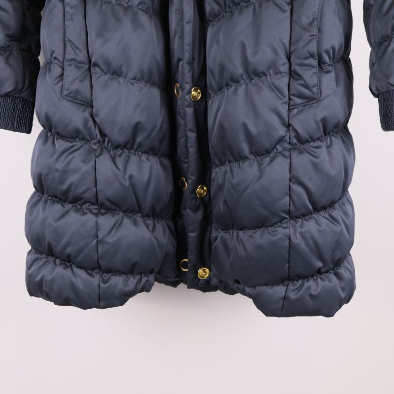 Närbild nederdelen av mörkblå vadderad jacka