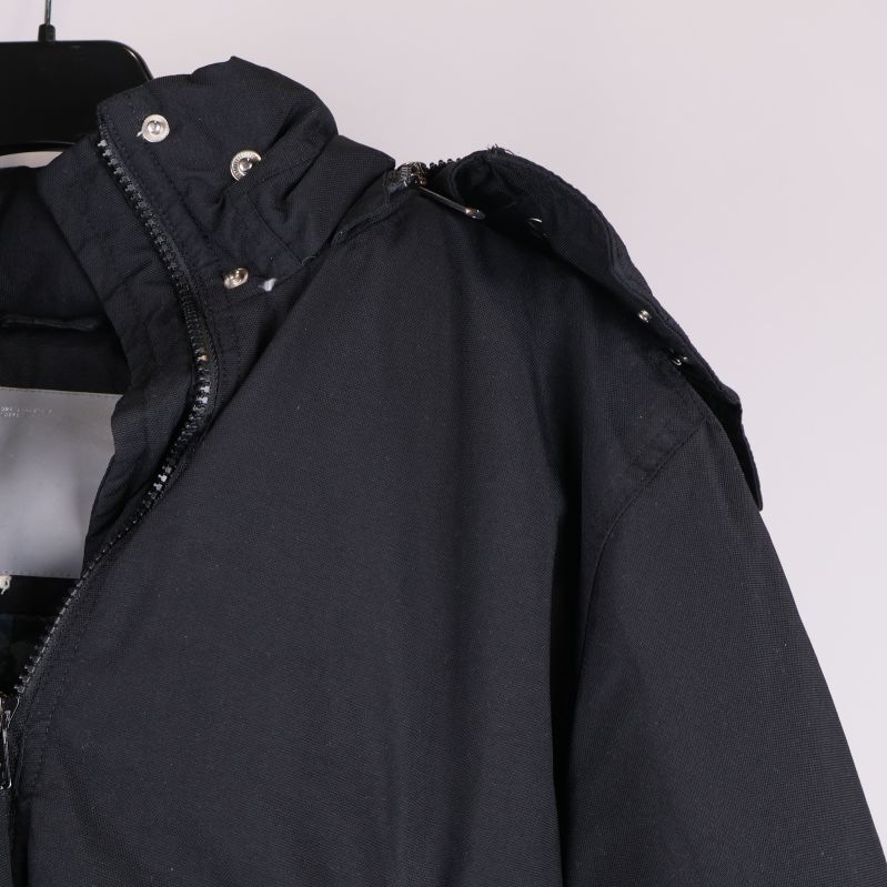 Närbild på jackans avtagbara huva och knappar