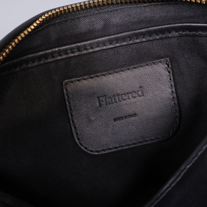 Insida av svart väska med Flattered logga