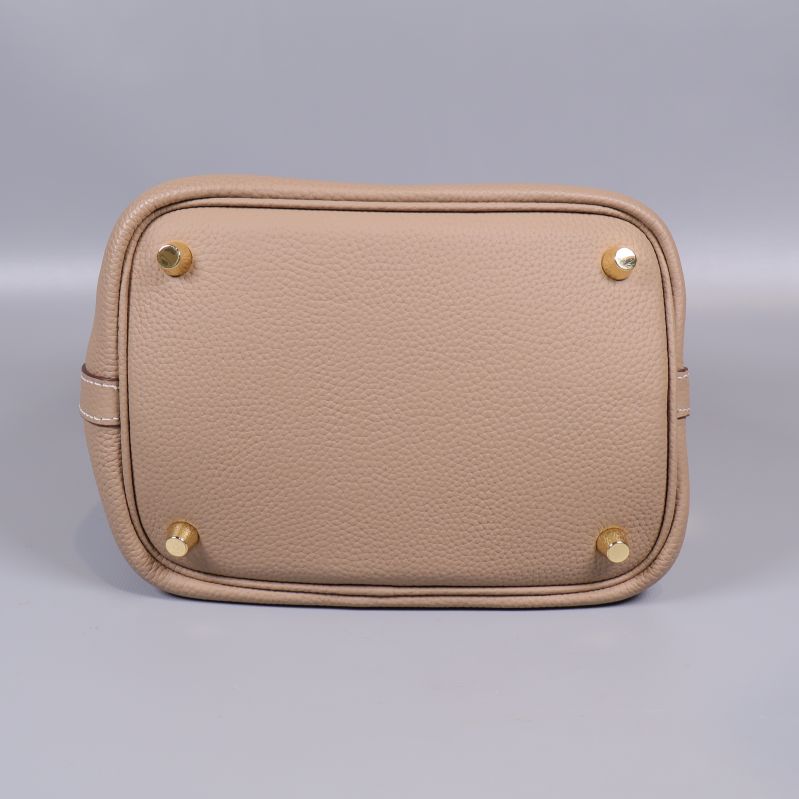 Väskans botten med fyra guldfärgade fötter