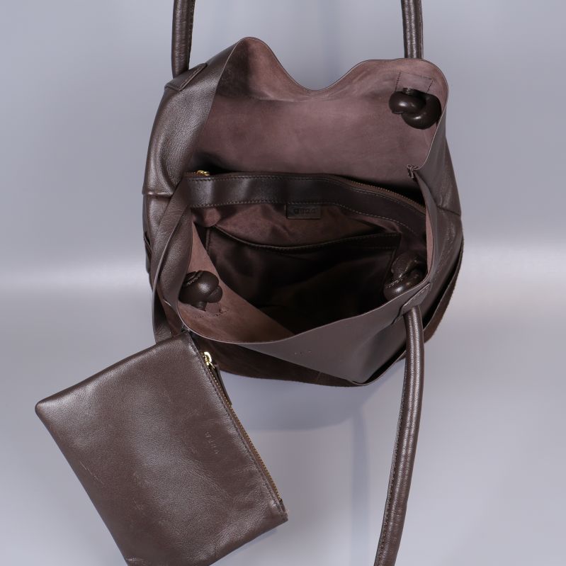 Insidan av brun bucketväska med innerficka i läderlook