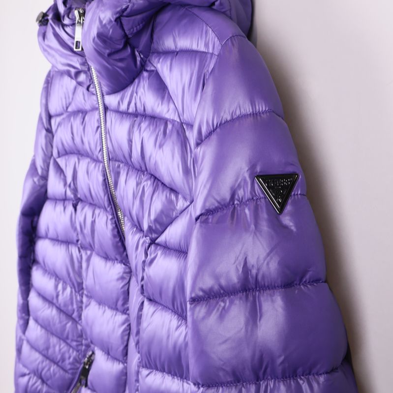 Sidan av lila jacka med GUESS-logotriangel på ärmen