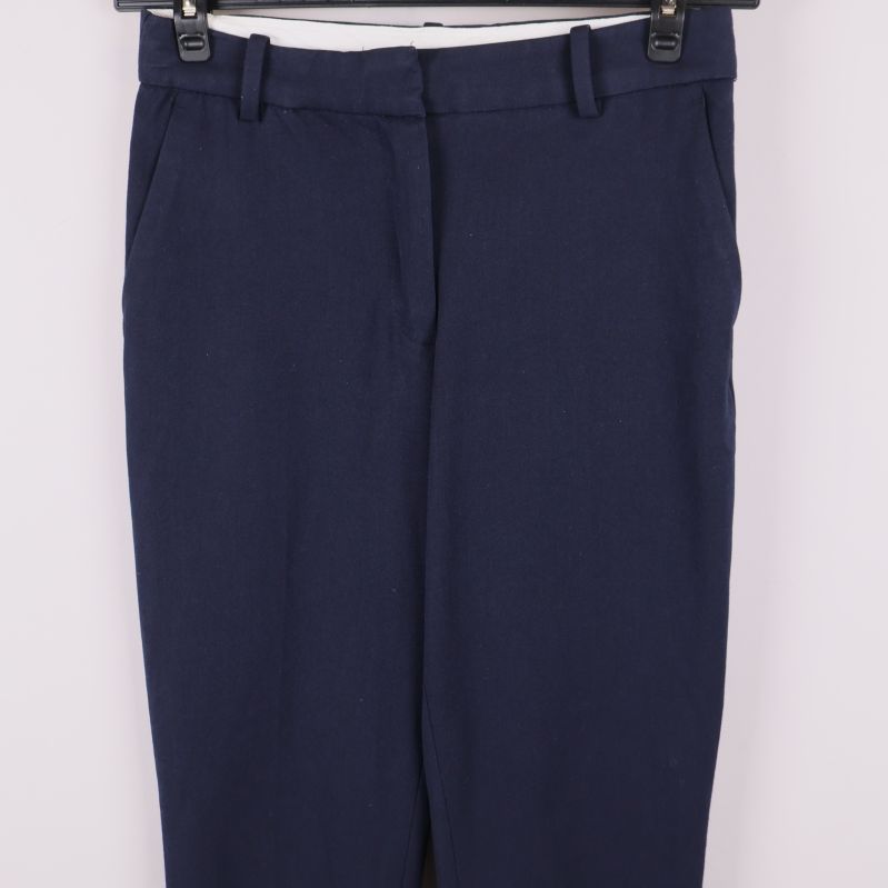 Närbild på midja och framficka av mörkblå byxor