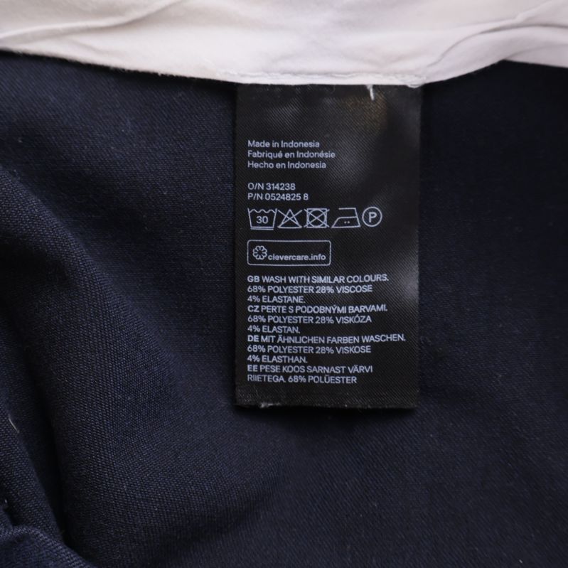 Materiallapp visar 64 procent viskos, 32 procent polyester, 4 procent elastan