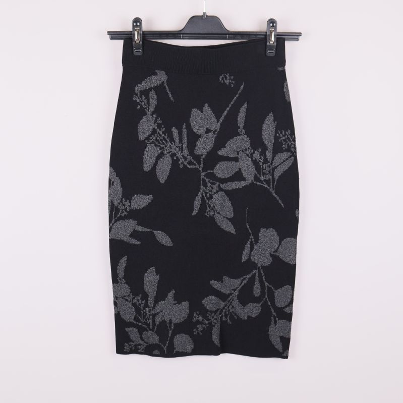 Framsidan av svart pennkjol med grått bladmönster