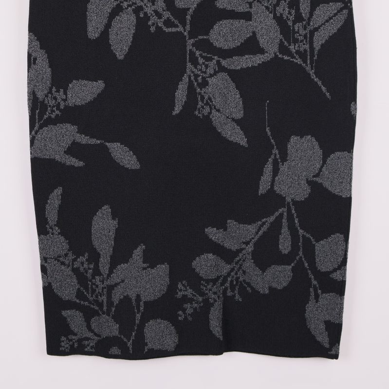 Närbild på nedre delen av kjolen med grått bladmönster