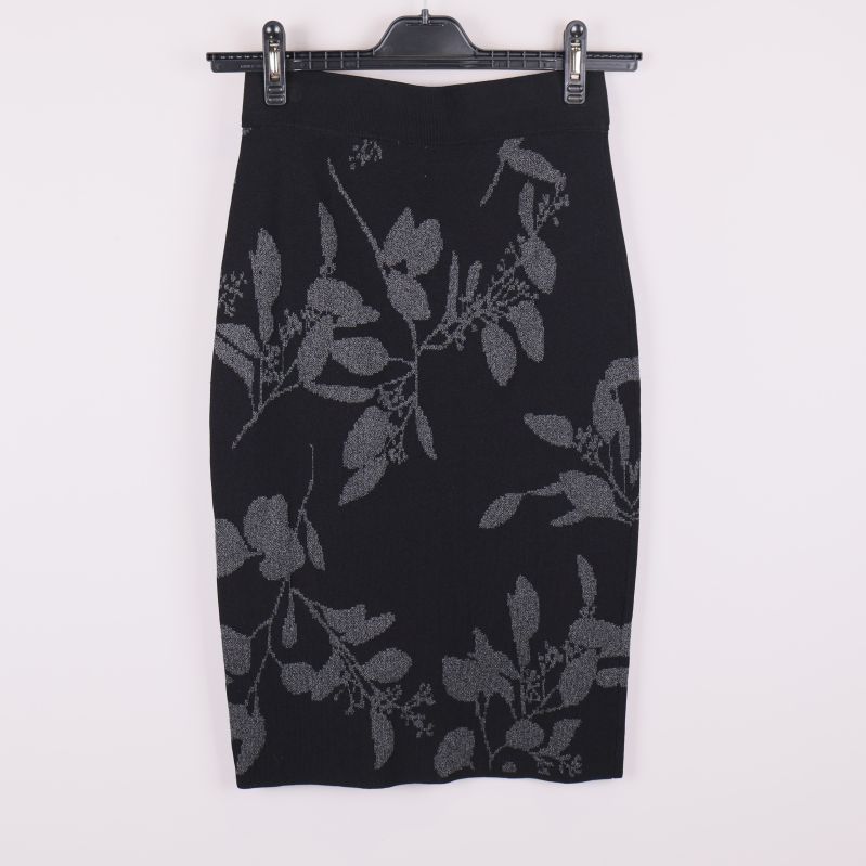 Baksidan av svart pennkjol med grått bladmönster