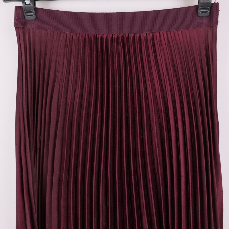 Närbild av plisserad kjols överdel och resårmidja