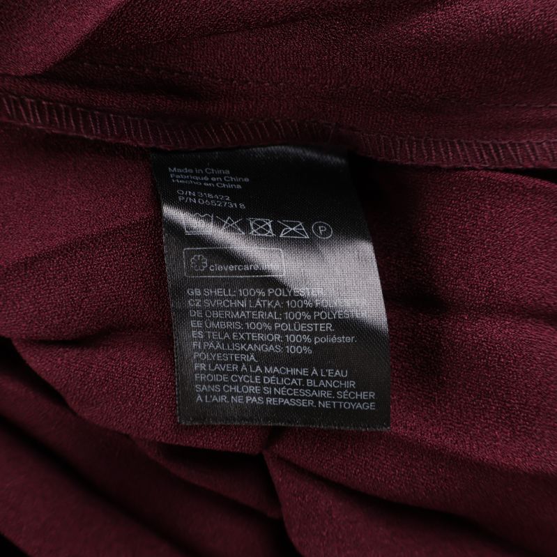 Tvättrådsetikett som visar 100% polyester i kjolen