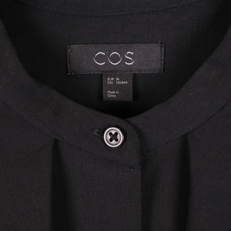 Närbild på COS-logotyp i nacke