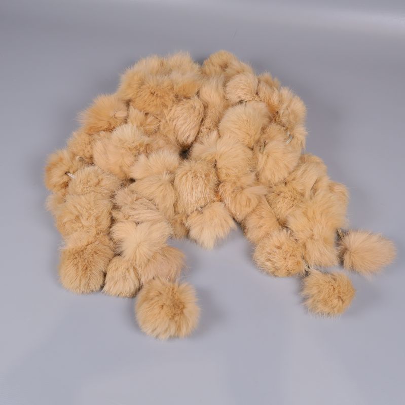 Pälskrage med stora, ljusbruna bollar på grå bakgrund