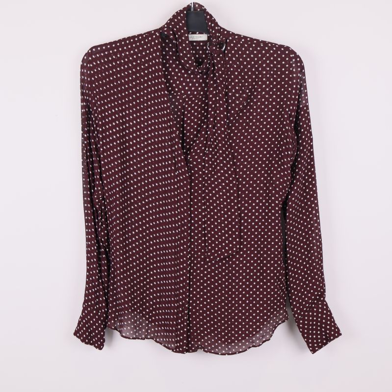 Framifrån av vinröd blus med vita stjärnor och knytband