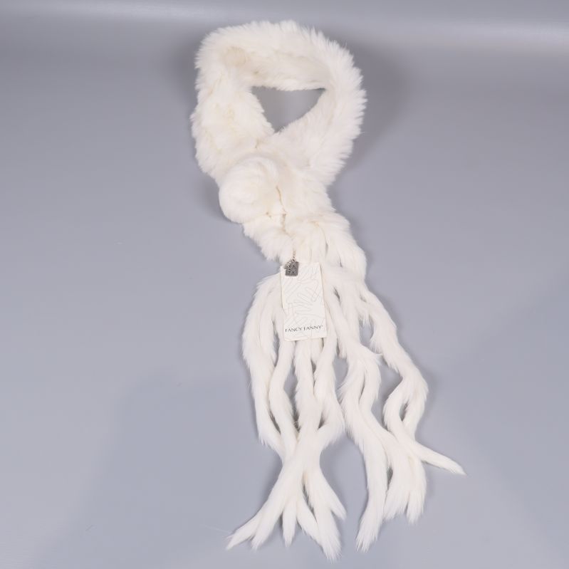 Vit scarf med tofsar arrangerad i en ring på grått underlag